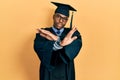 Young african american man wearing graduation cap and ceremony robe rejection expression crossing arms doing negative sign, angry Royalty Free Stock Photo