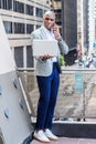 Young African American man talking on cell phone, working on laptop computer outside in New York City Royalty Free Stock Photo