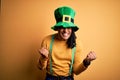Young african american man wearing green hat celebrating saint patricks day very happy and excited doing winner gesture with arms Royalty Free Stock Photo