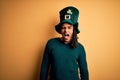 Young african american man wearing green hat with clover celebrating saint patricks day winking looking at the camera with sexy