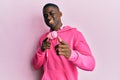 Young african american man wearing gym clothes and using headphones pointing fingers to camera with happy and funny face Royalty Free Stock Photo