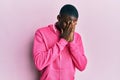 Young african american man wearing gym clothes and using headphones with sad expression covering face with hands while crying Royalty Free Stock Photo