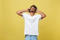 Young African American man wearing headphone and enjoy music over yellow gold Background Royalty Free Stock Photo