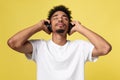 Young African American man wearing headphone and enjoy music over yellow gold Background Royalty Free Stock Photo