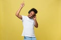 Young African American man wearing headphone and enjoy music over yellow gold Background Royalty Free Stock Photo