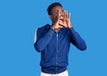 Young african american man wearing sportswear shouting angry out loud with hands over mouth Royalty Free Stock Photo
