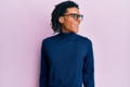 Young african american man wearing turtleneck sweater and glasses looking to side, relax profile pose with natural face and