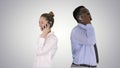 Young African American man and woman standing back to back making phone calls on gradient background. Royalty Free Stock Photo