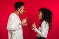 Young african american match emotionally quarreling on red background in studio Royalty Free Stock Photo