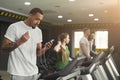 Black sporty man on treadmill in fitness club