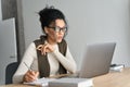 Young African American mixed race girl sitting at desk with pc indoors.