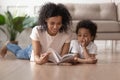 Young black mom reading book with son at home Royalty Free Stock Photo