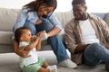 Young African American parents feeding child from bottle Royalty Free Stock Photo