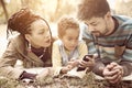 Young African American parents in park with daughter using mobil Royalty Free Stock Photo