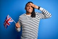 Young african american patriotic man with dreadlocks holding united kingdom flag stressed with hand on head, shocked with shame Royalty Free Stock Photo