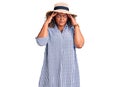 Young african american plus size woman wearing summer hat with hand on head for pain in head because stress