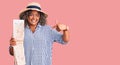 Young african american plus size woman wearing summer hat holding city map pointing finger to one self smiling happy and proud Royalty Free Stock Photo