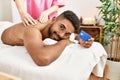 Young african american reciving back massage and holding credit card at beauty center Royalty Free Stock Photo