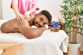 Young african american reciving back massage and holding credit card at beauty center Royalty Free Stock Photo