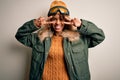 Young african american skier woman with curly hair wearing snow sportswear and ski goggles Doing peace symbol with fingers over Royalty Free Stock Photo