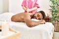 Young african american smiling happy reciving back massage at beauty center Royalty Free Stock Photo