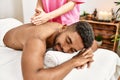 Young african american smiling happy reciving back massage at beauty center Royalty Free Stock Photo