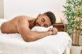 Young african american smiling happy relaxed lying on massage table at beauty center Royalty Free Stock Photo