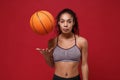 Young african american sports fitness basketball player woman in sportswear working out isolated on red wall background Royalty Free Stock Photo