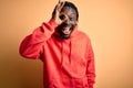 Young african american sporty man wearing sweatshirt with hoodie over yellow background doing ok gesture with hand smiling, eye Royalty Free Stock Photo