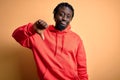 Young african american sporty man wearing sweatshirt with hoodie over yellow background looking unhappy and angry showing Royalty Free Stock Photo