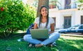 Young african american student woman smiling happy using computer laptop sitting on the grass at the university campus Royalty Free Stock Photo