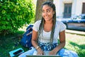 Young african american student woman smiling happy using computer laptop sitting on the grass at the university campus Royalty Free Stock Photo