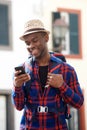 Young african american travel man looking at mobile phone while walking on street with backpack Royalty Free Stock Photo