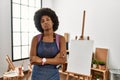 Young african american woman with afro hair at art studio looking sleepy and tired, exhausted for fatigue and hangover, lazy eyes