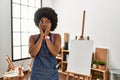 Young african american woman with afro hair at art studio tired hands covering face, depression and sadness, upset and irritated