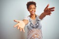 Young african american woman with afro hair wearing a bikini over white isolated background looking at the camera smiling with Royalty Free Stock Photo