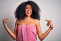 Young african american woman with afro hair wearing a body towel after beauty care shower looking confident with smile on face, Royalty Free Stock Photo