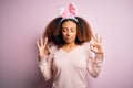 Young african american woman with afro hair wearing bunny ears over pink background relaxed and smiling with eyes closed doing Royalty Free Stock Photo