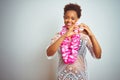 Young african american woman with afro hair wearing flower hawaiian lei over isolated background smiling in love showing heart Royalty Free Stock Photo