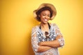 Young african american woman with afro hair wearing summer hat over white isolated background happy face smiling with crossed arms Royalty Free Stock Photo