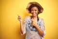 Young african american woman with afro hair wearing summer hat over white isolated background smiling and looking at the camera Royalty Free Stock Photo