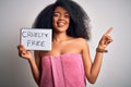 Young african american woman with afro hair wearing a towel asking for cruelty free beauty very happy pointing with hand and