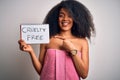 Young african american woman with afro hair wearing a towel asking for cruelty free beauty very happy pointing with hand and