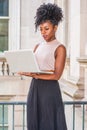 Young African American woman with afro hairstyle wearing sleeveless light color top, black skirt, standing in vintage office Royalty Free Stock Photo