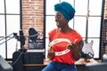 Young african american woman artist singing song playing tambourine at music Royalty Free Stock Photo