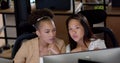 Young African American woman and biracial woman collaborate in a business office