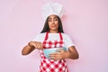 Young african american woman with braids cooking using baker whisk looking at the camera blowing a kiss being lovely and sexy