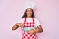 Young african american woman with braids cooking using baker whisk smiling and laughing hard out loud because funny crazy joke Royalty Free Stock Photo