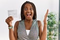 Young african american woman with braids holding covid record card celebrating victory with happy smile and winner expression with