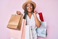 Young african american woman with braids holding shopping bags smiling and laughing hard out loud because funny crazy joke Royalty Free Stock Photo